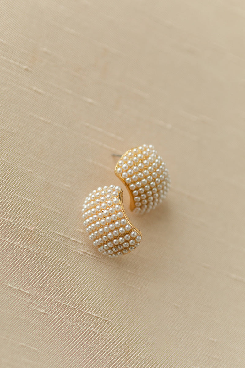 Elegant pearl-encrusted earrings with a lustrous golden finish, featuring a structured, dome-like design.