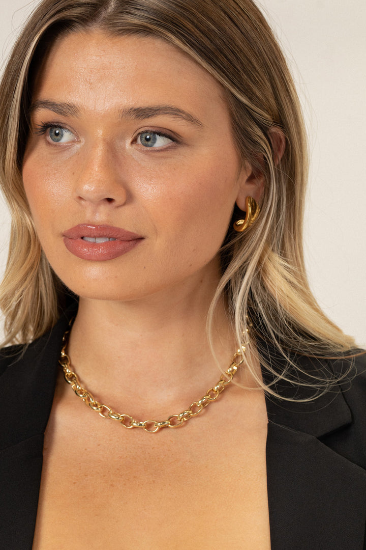 A gold-plated chain link necklace with a circular design, featuring an adjustable length between 15 and 17.5 inches.