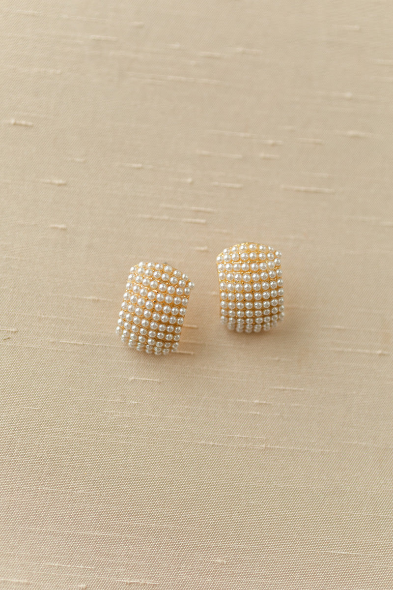 Sparkling pearl-encrusted earrings with a curved, domed design, offering a touch of elegant glamour.