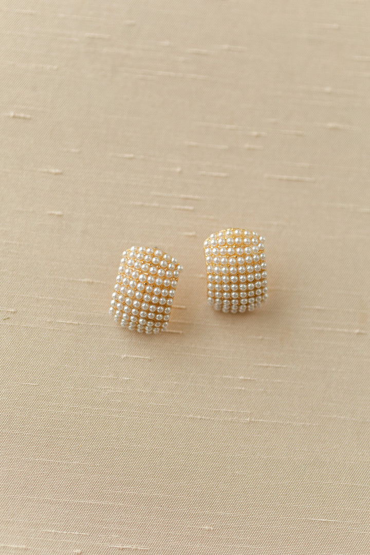 Sparkling pearl-encrusted earrings with a curved, domed design, offering a touch of elegant glamour.