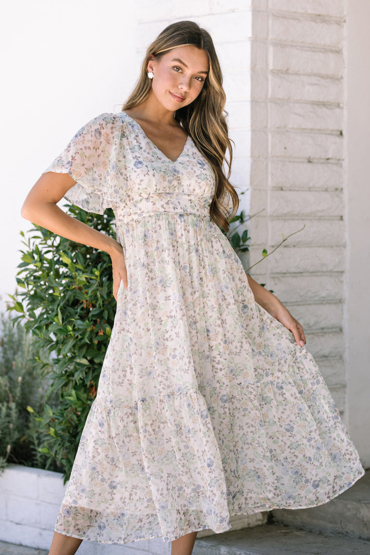 Floral print dress with flutter sleeves and a tiered, flowing skirt; floaty and feminine style.