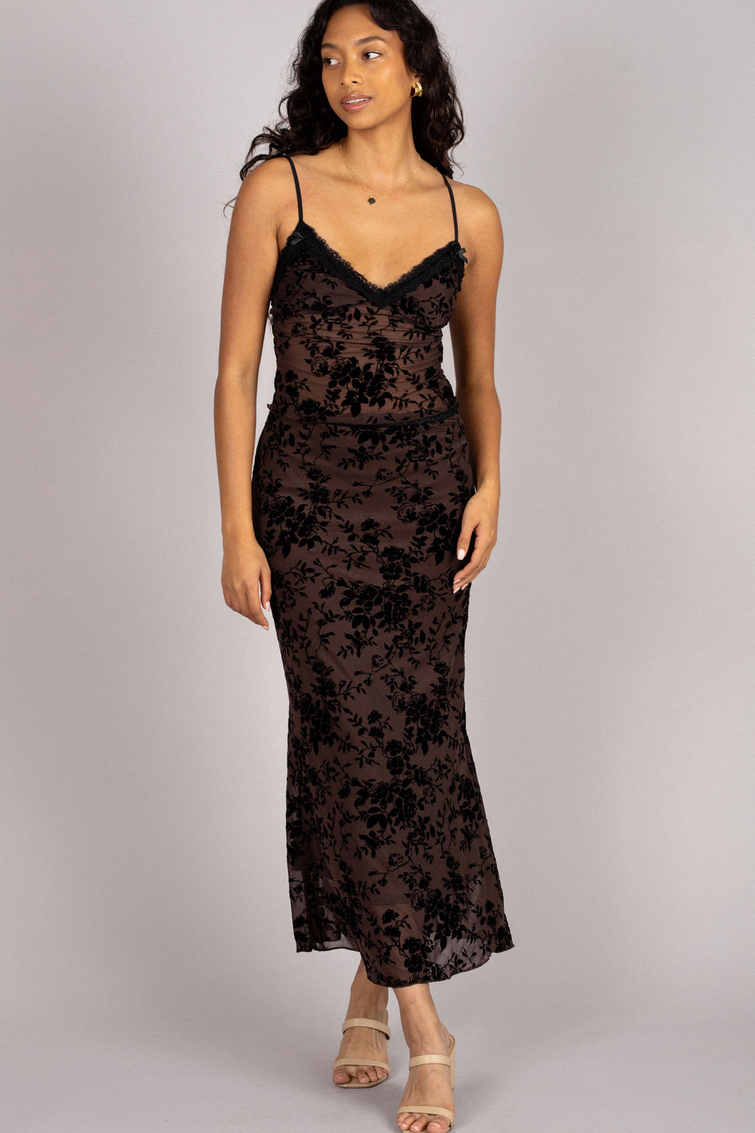 A black floral burnout maxi dress with a V-neckline, spaghetti straps, and a fitted silhouette.