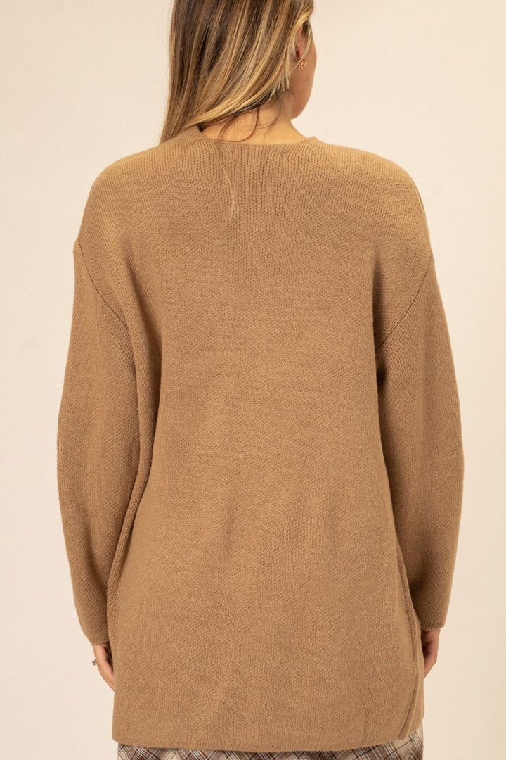 Tan knit cardigan with front pockets and long sleeves, modeled from behind.