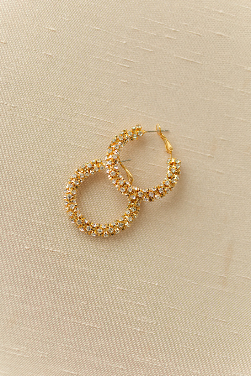 Sparkling gold-tone hooped earrings with a cluster of gleaming crystals, creating a dazzling, statement-making accessory.