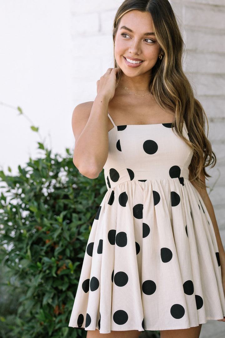 A polka dot dress with a fitted bodice and a voluminous skirt, creating a feminine and playful look.