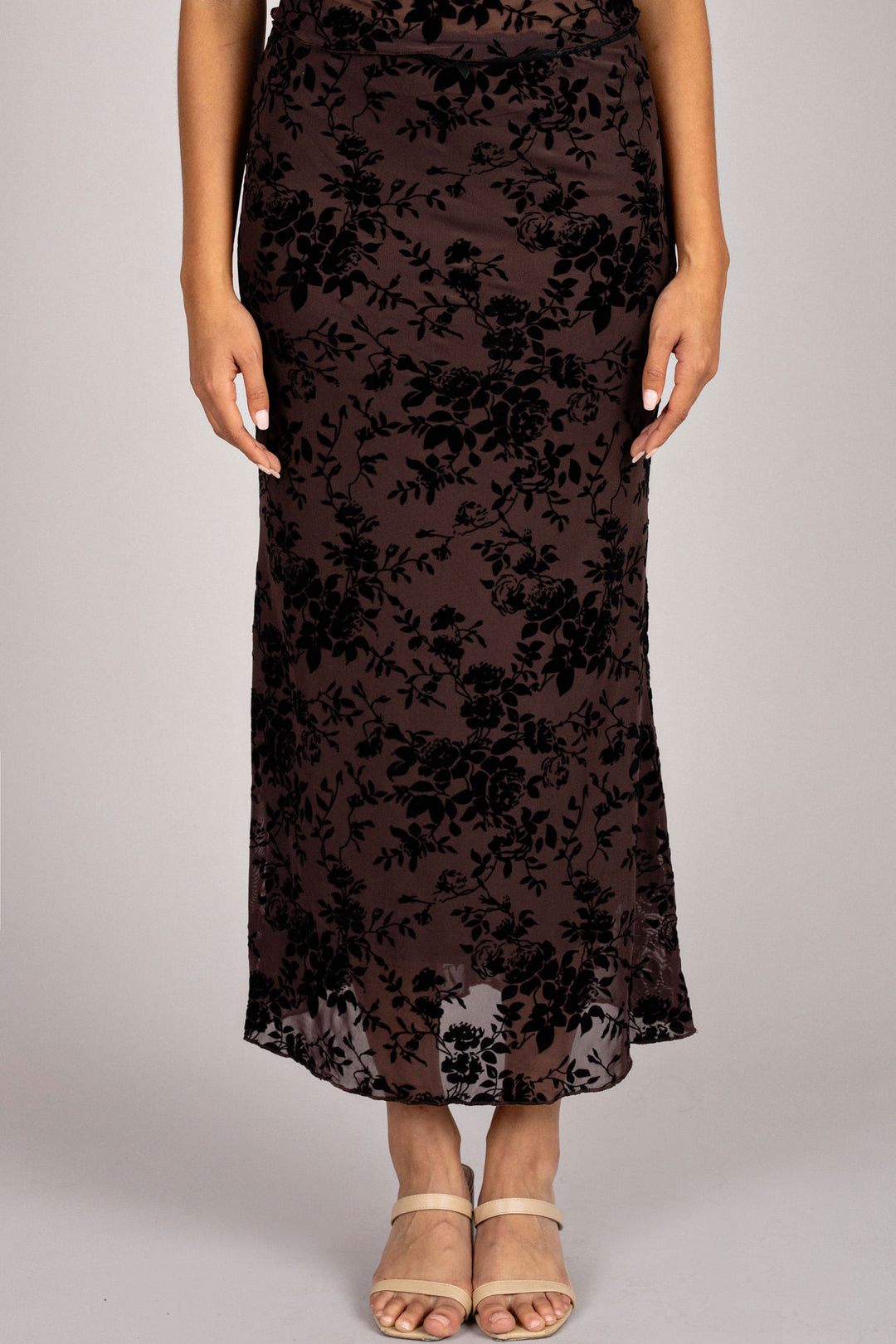 A long, flowing black skirt with an elegant floral burnout pattern, creating a sophisticated and stylish look.