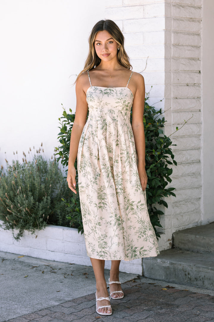 A sleeveless floral print midi dress with a fitted bodice and flowing skirt, designed with adjustable spaghetti straps and worn by a 5'10" model in a size small.