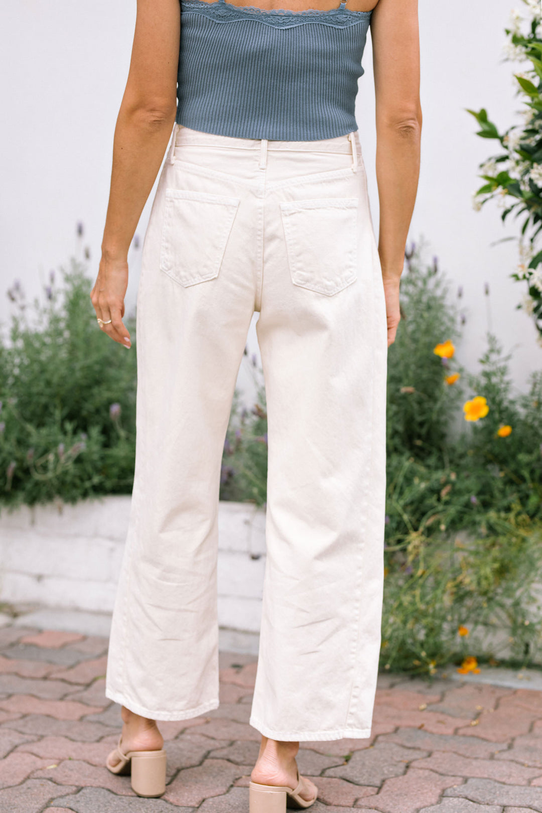 White high-waisted barrel jeans with a relaxed, wide-leg silhouette and front pockets.