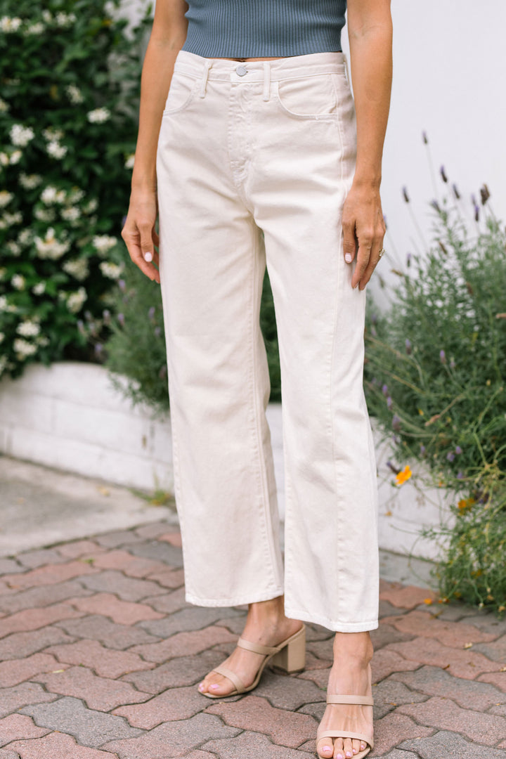 White barrel jeans with a relaxed, wide-leg silhouette, five pockets, and a button-zipper fly closure.