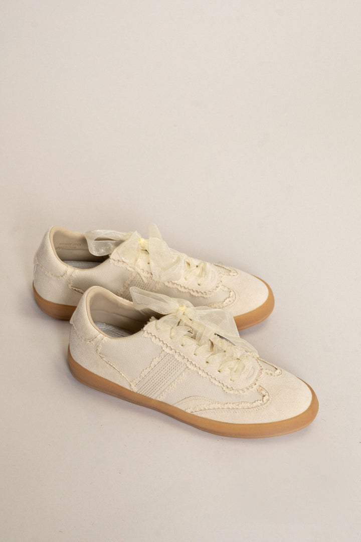 Cream-colored lace and tulle sneakers with gum rubber soles and contrast stitching.