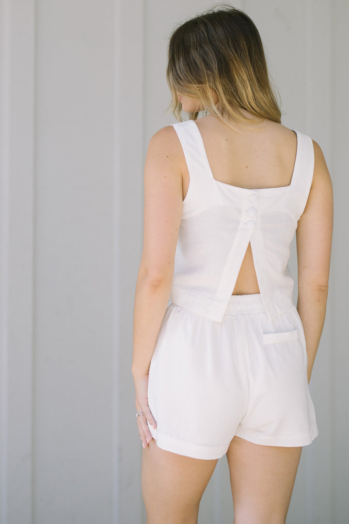 A white square-neck tank top with a button-up back, worn by a 5'7" model in size small.