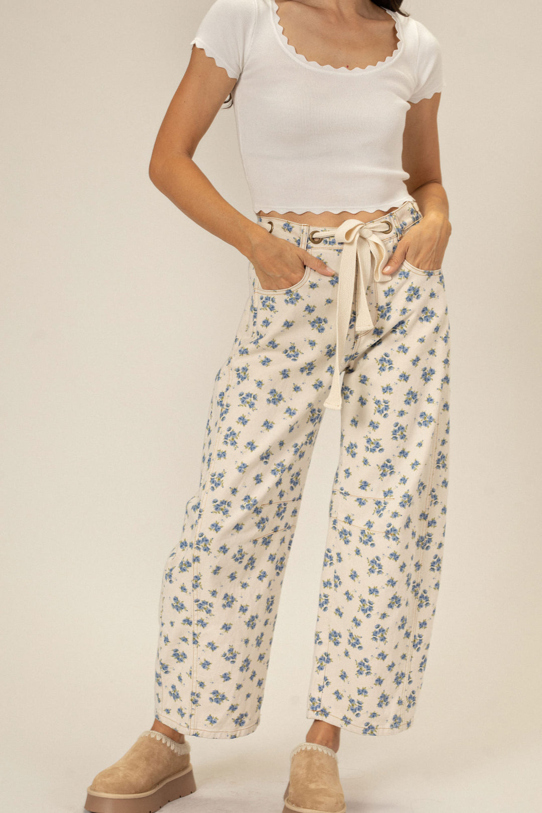 Ivory barrel pants with delicate blue floral print, featuring a tied waist, wide legs, and a ribbed white crop top.