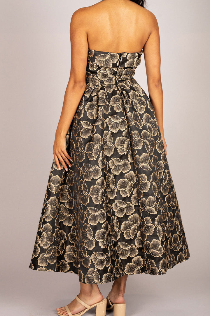 A black floral jacquard dress with a strapless, fitted bodice and a full, midi-length skirt.