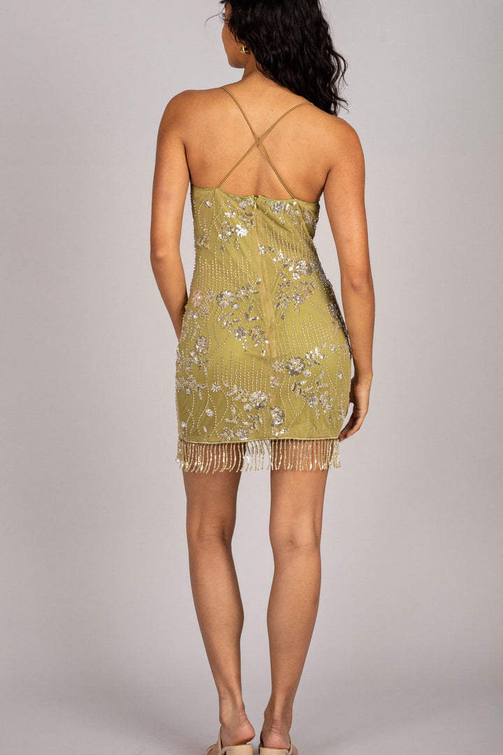 A shimmering golden dress with delicate floral sequin patterns and a flattering fringe trim along the hemline.