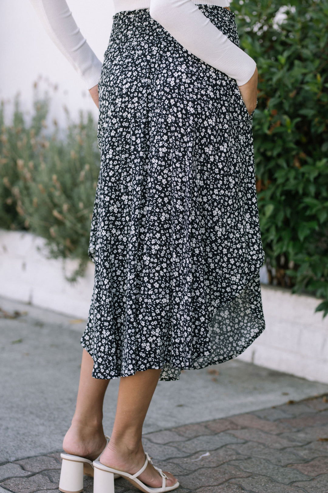 Black and white floral print skirt with round hem, displayed on model's lower body.