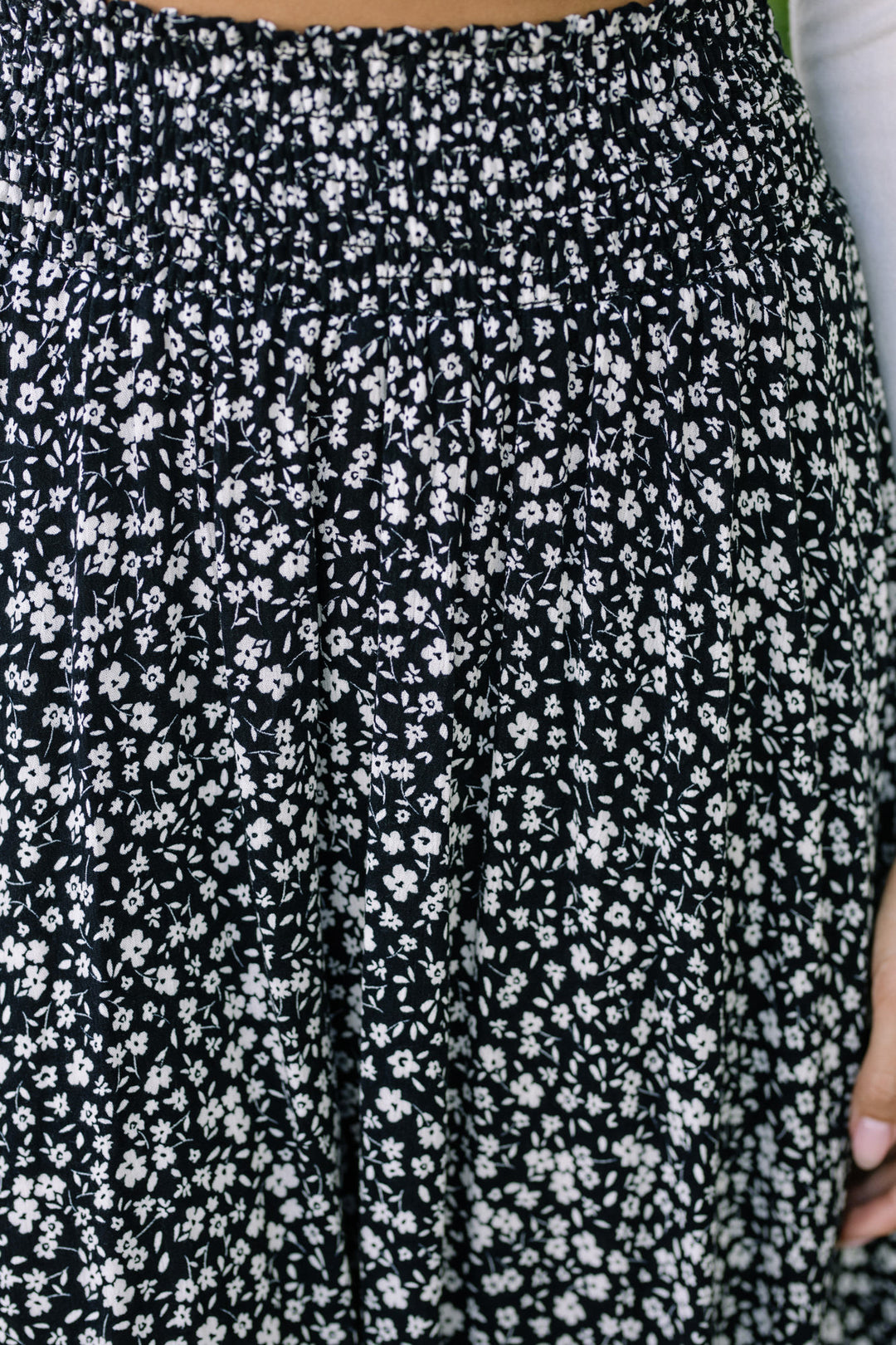 A black and white floral print skirt with a rounded hemline, featuring an elastic waistband for a comfortable, flattering fit.