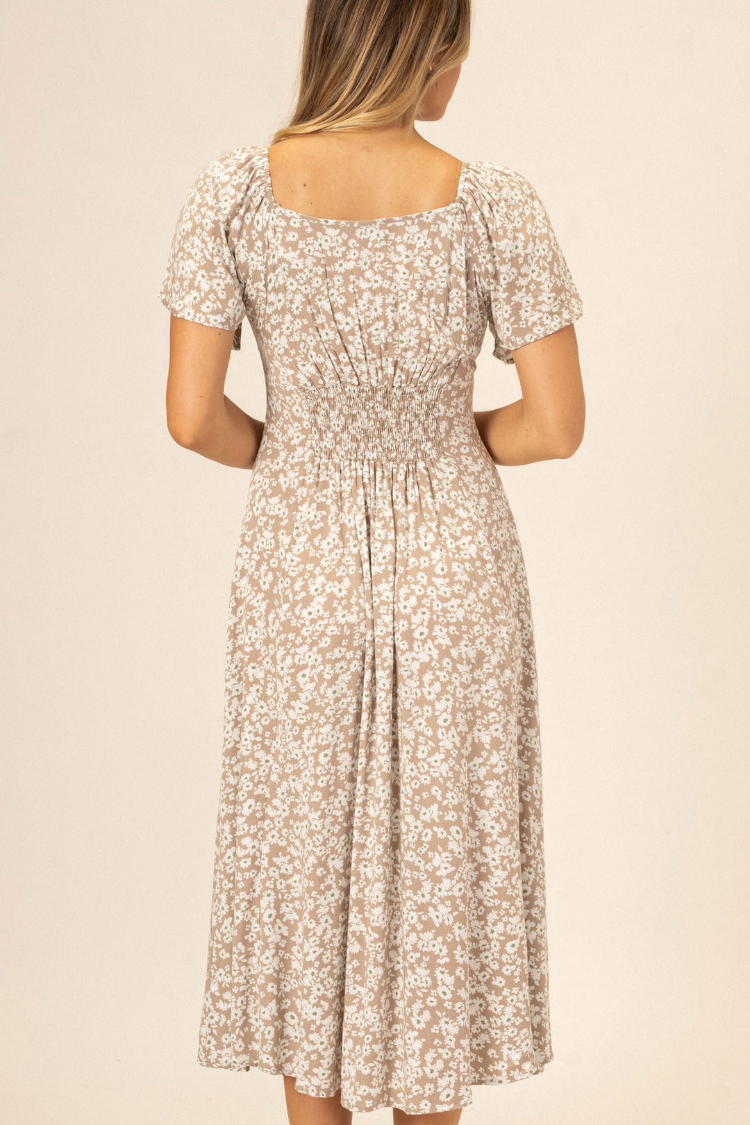 Floral patterned midi dress with short puff sleeves, smocked waistline, and scoop neckline.