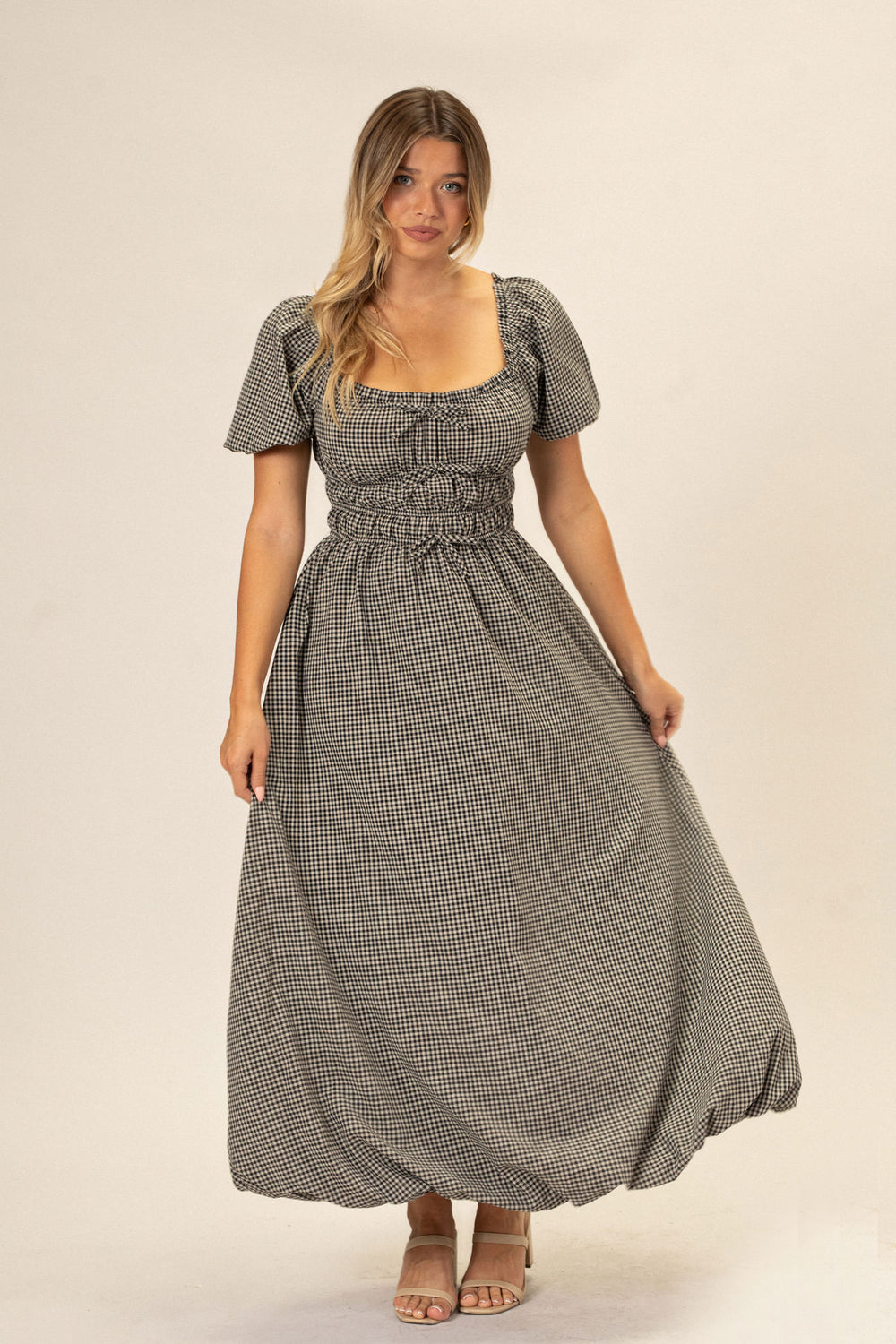 A gingham dress with a bubble hem and puff sleeves in a black and white checkered pattern, worn by a woman with long blonde hair.