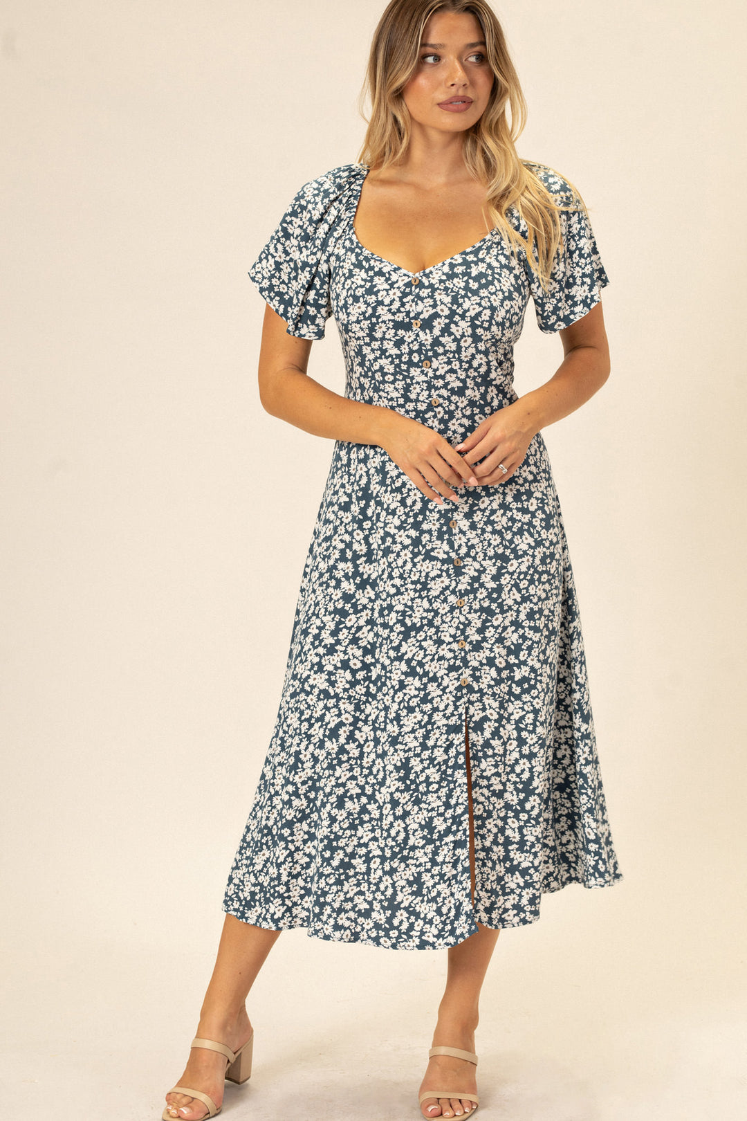 A blue and white floral print dress with a V-neckline, puff sleeves, and a midi-length, flowing skirt.