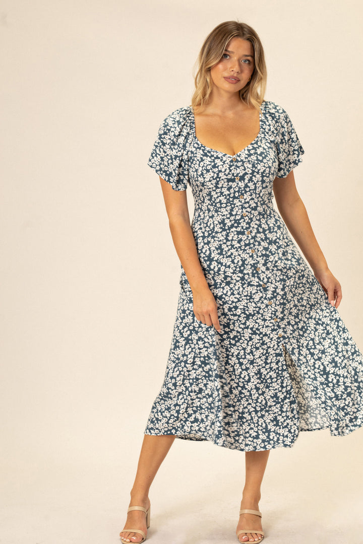 A blue and white floral print dress with puffed sleeves, a square neckline, and a midi-length skirt.