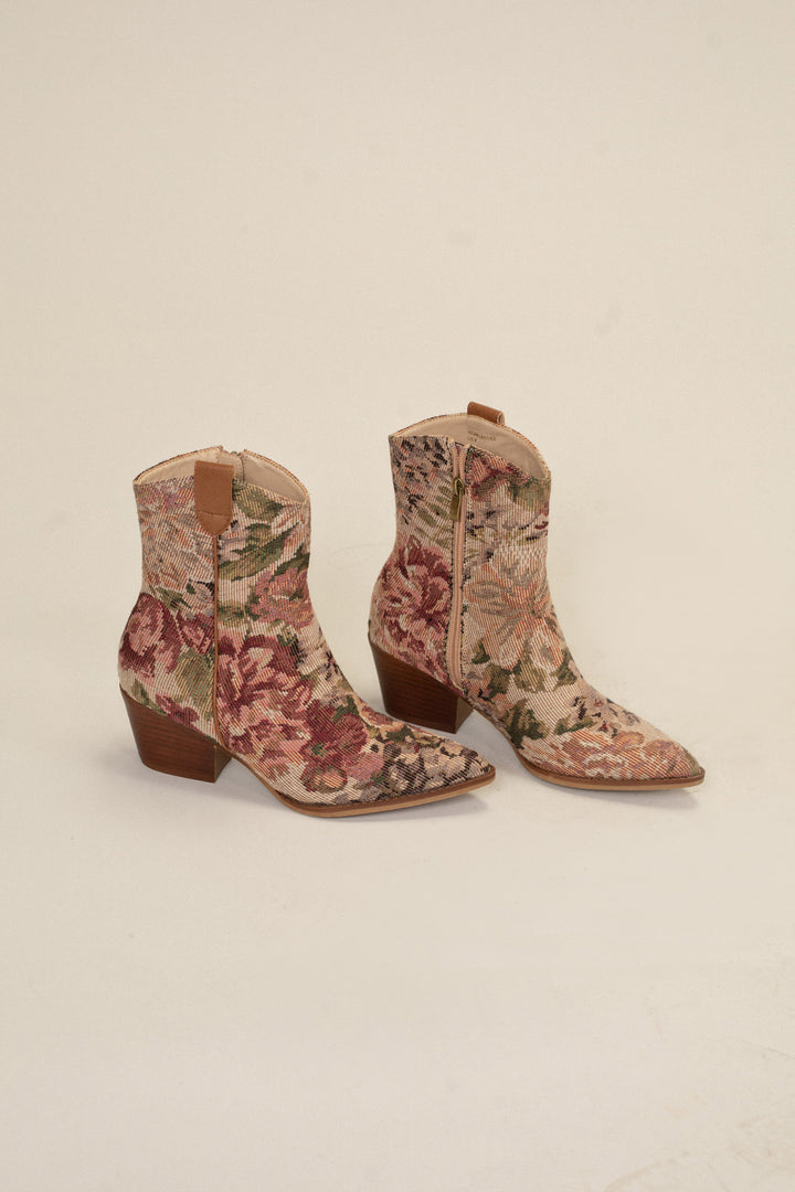 Floral-patterned tapestry booties with brown leather trim and stacked heels.