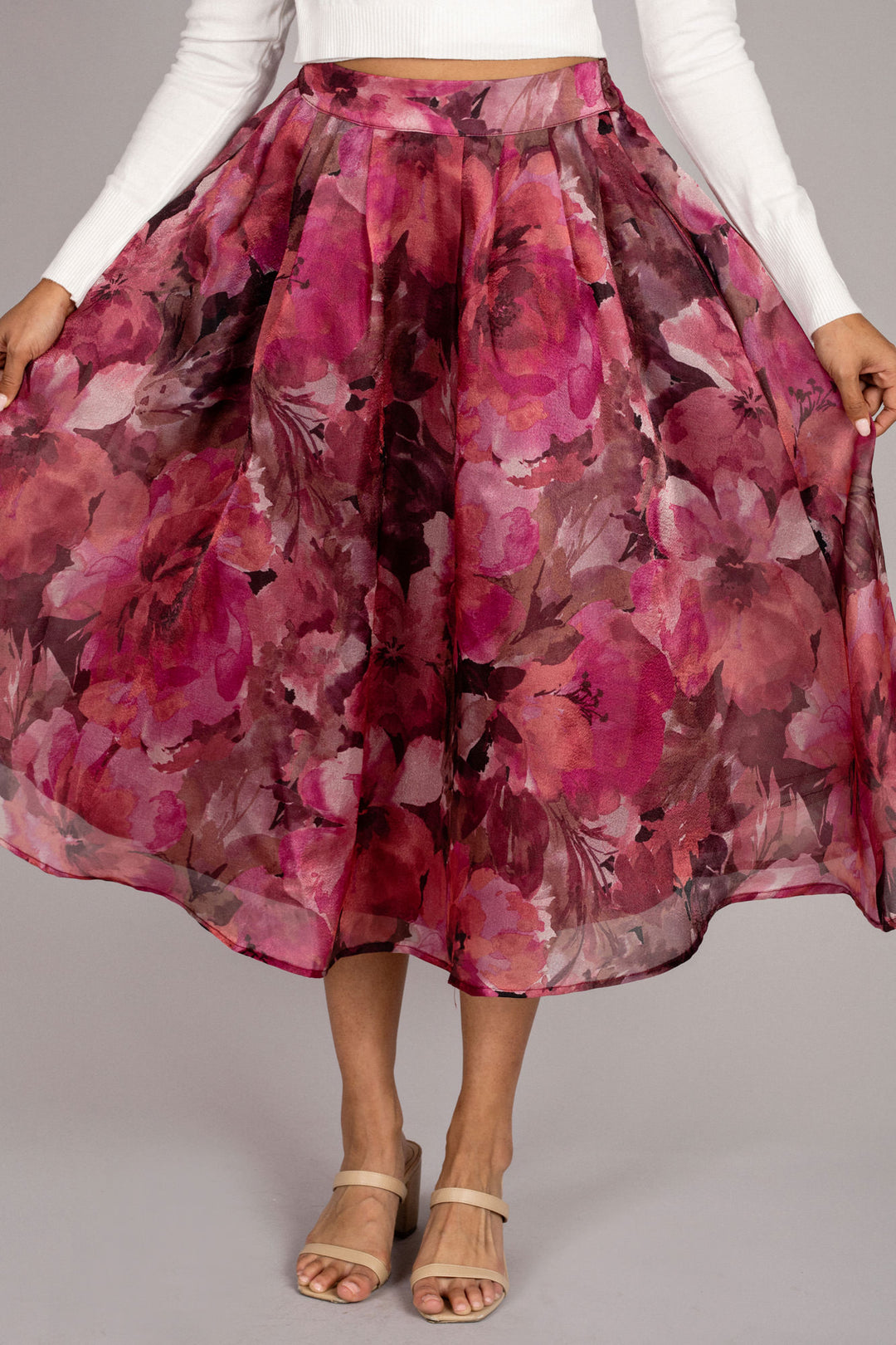 Vibrant floral midi skirt in shades of pink, featuring a full, pleated silhouette and a high waistline.