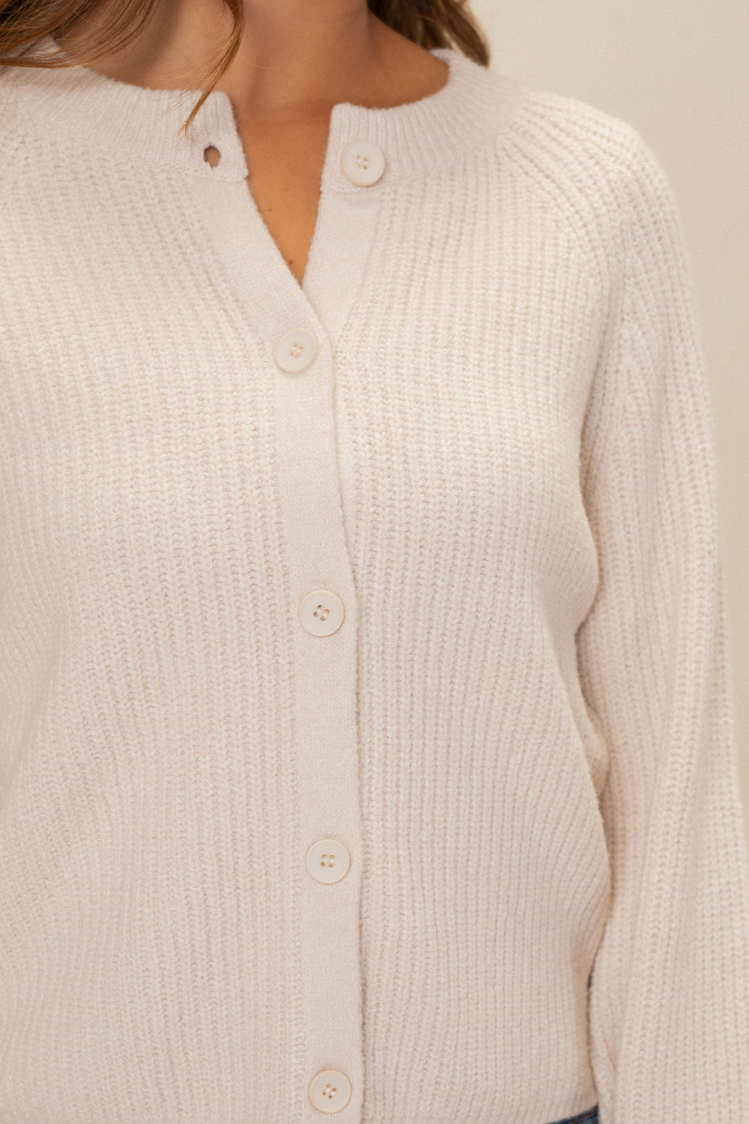 Soft, creamy white ribbed knit cardigan with button front closure and high collar.