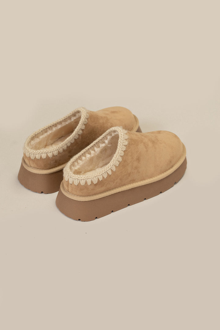 Tan suede slippers with fuzzy lining, crochet trim, and platform soles.