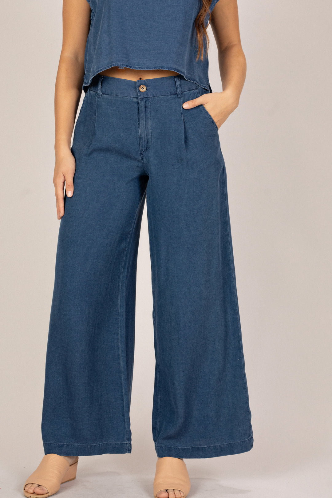 Person wearing blue wide-leg pants on a plain background