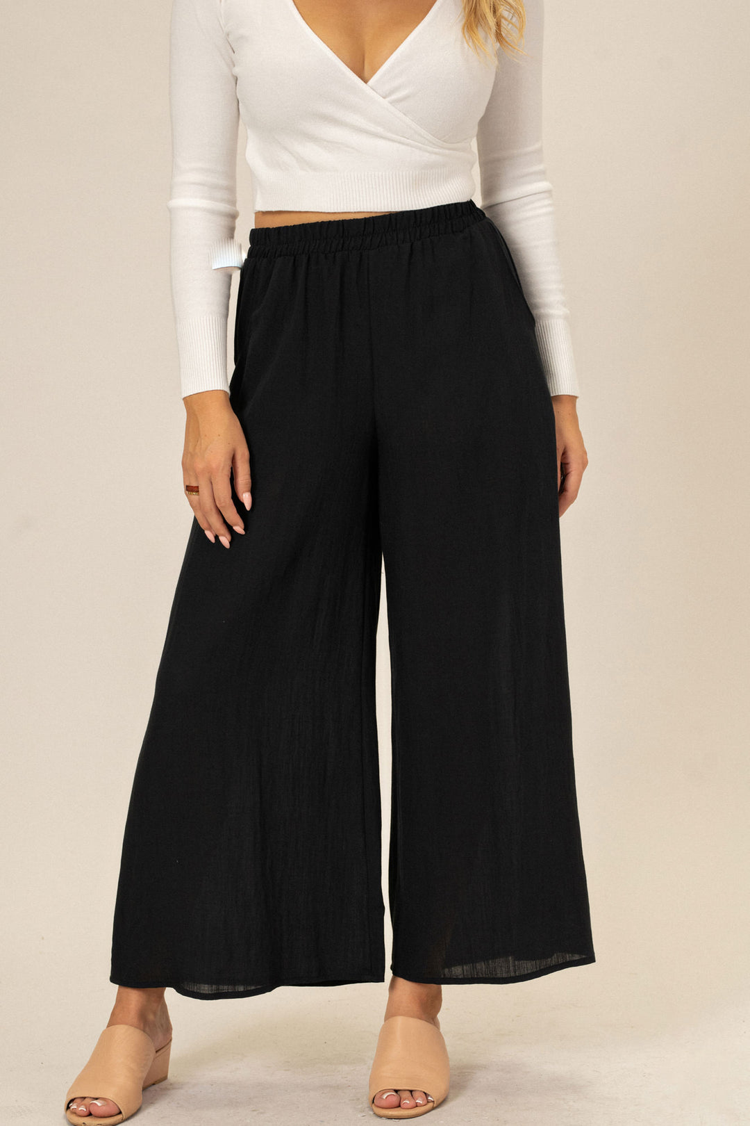 A pair of black, wide-leg pants with an elastic waistband and a flowing, straight leg design.