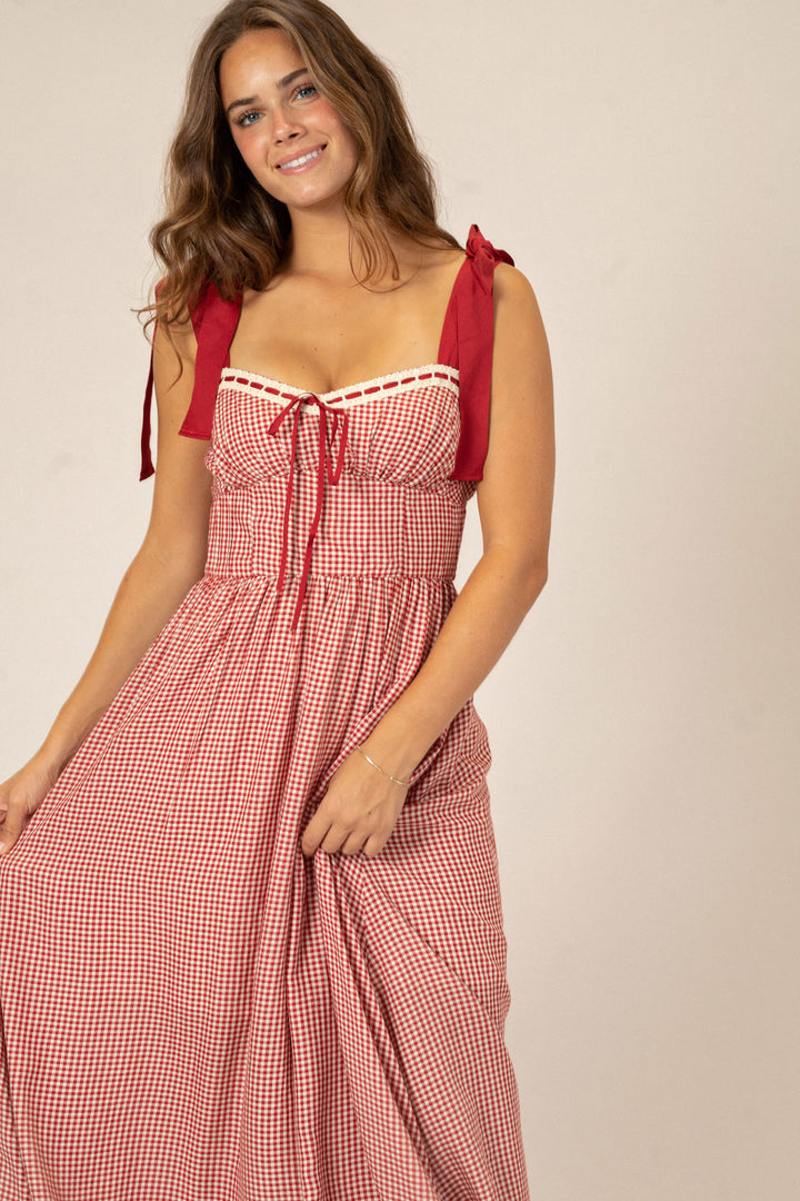 Red and white gingham print dress with sweetheart neckline, adjustable shoulder straps, and full skirt.