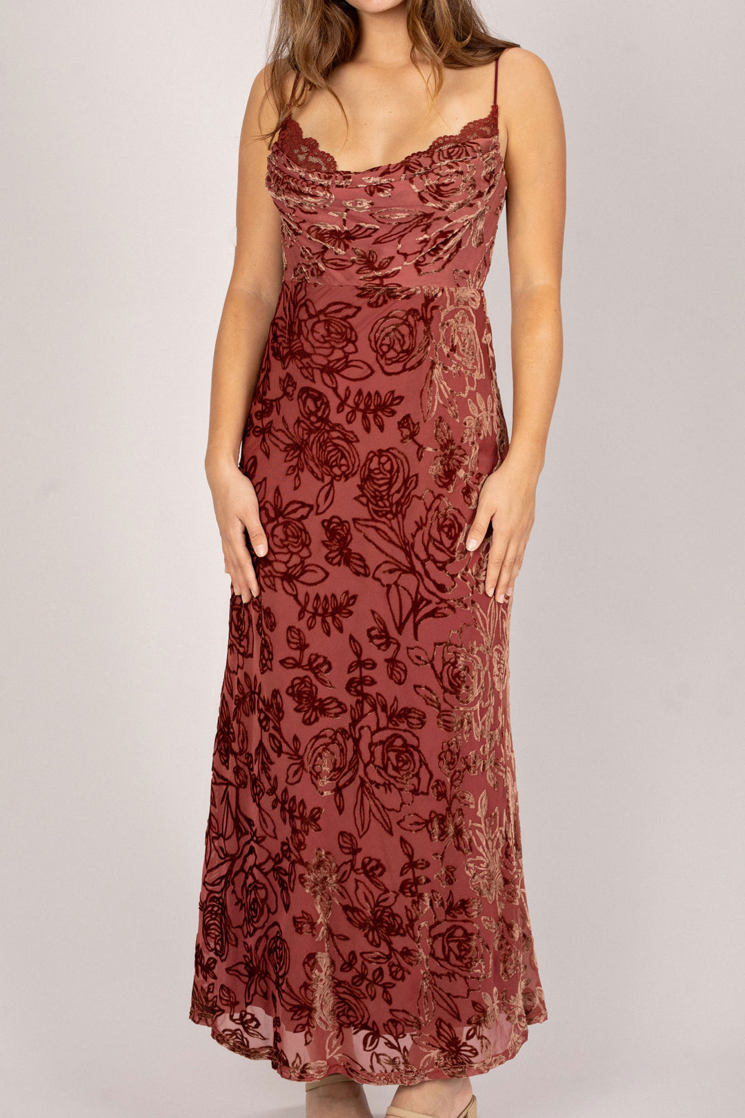 A burgundy-colored cowl neck dress with allover floral embroidery and a slender silhouette.