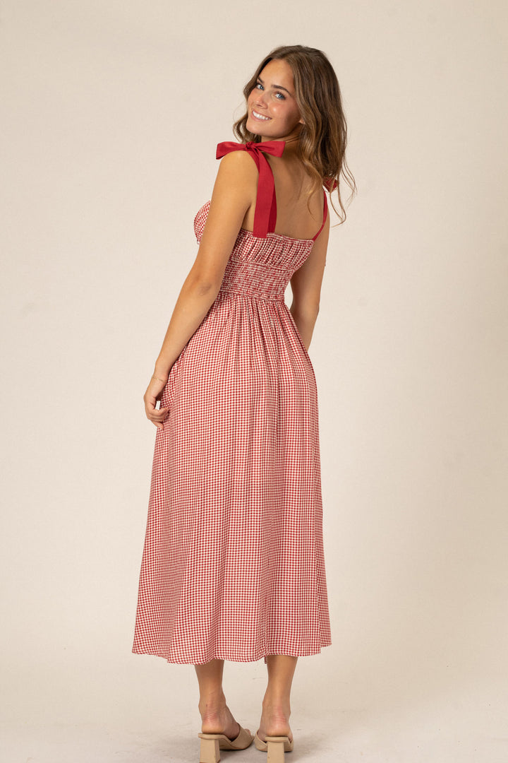 Bright red and white gingham print dress with a sweetheart neckline, bow detail, and midi-length skirt.