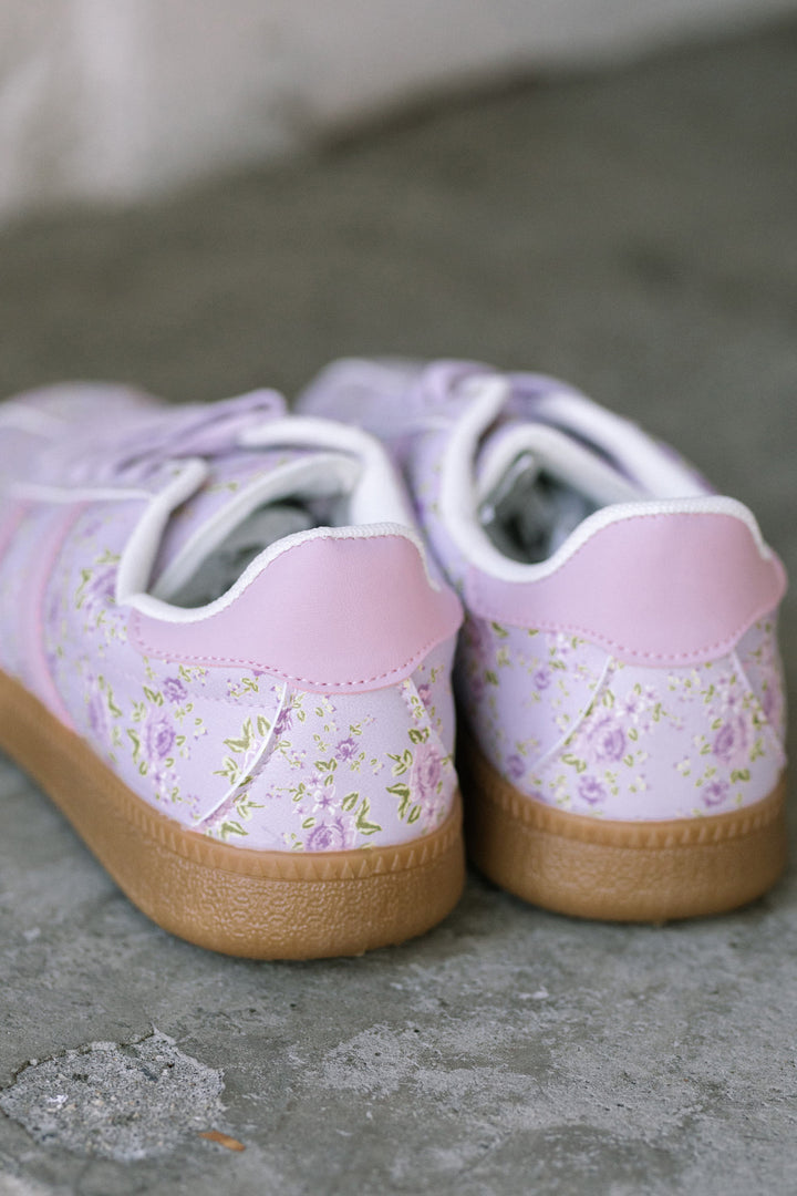 Lightweight floral-patterned sneakers in soft lilac and pink tones with lace-up closure and rubber sole.