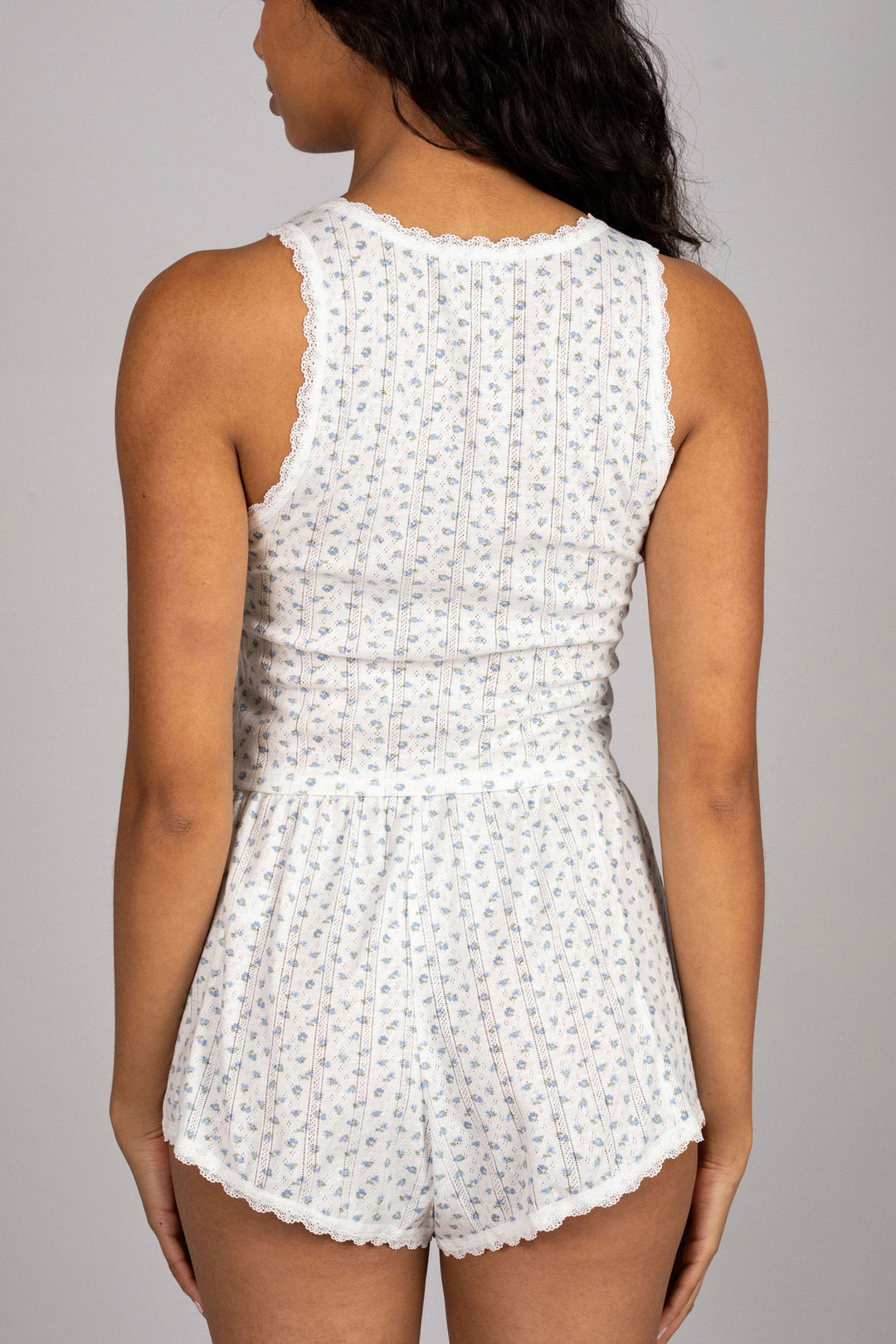 A white floral-patterned sleepwear set with a lace-trimmed tank top and matching shorts.