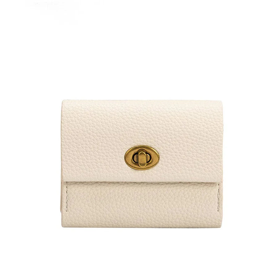 A white vegan leather card wallet with a turn-lock closure, brass-tone hardware, and two card slots, measuring 4"W x 3.25"H x .75"D.