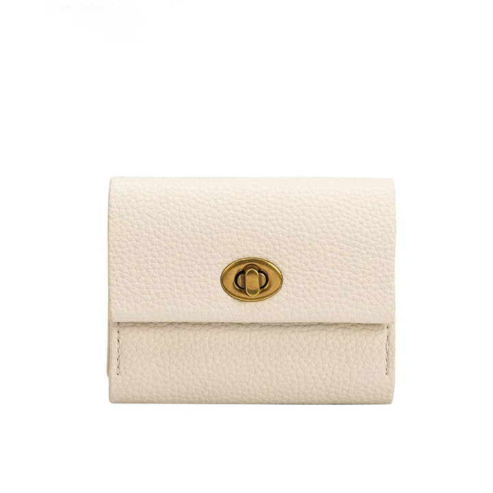 A white vegan leather card wallet with a turn-lock closure, brass-tone hardware, and two card slots, measuring 4"W x 3.25"H x .75"D.