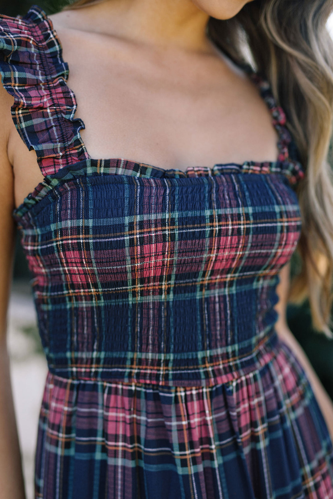 Colorful plaid dress with a smocked bodice and a flowy, tiered skirt.