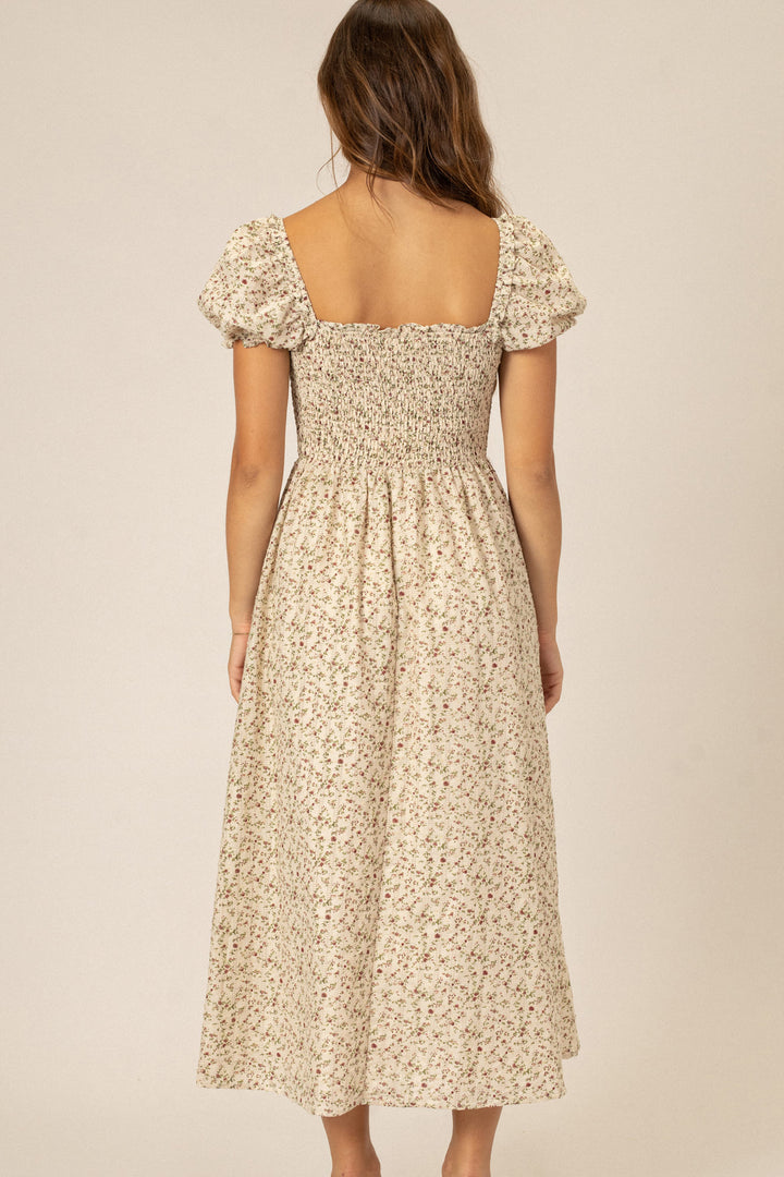 Beige floral-print midi dress with puff sleeves, shirred waist, and square neckline.