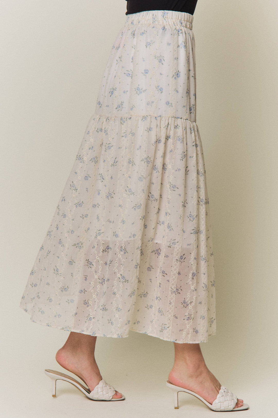 Cream floral tiered midi skirt with blue embroidered details, side view.