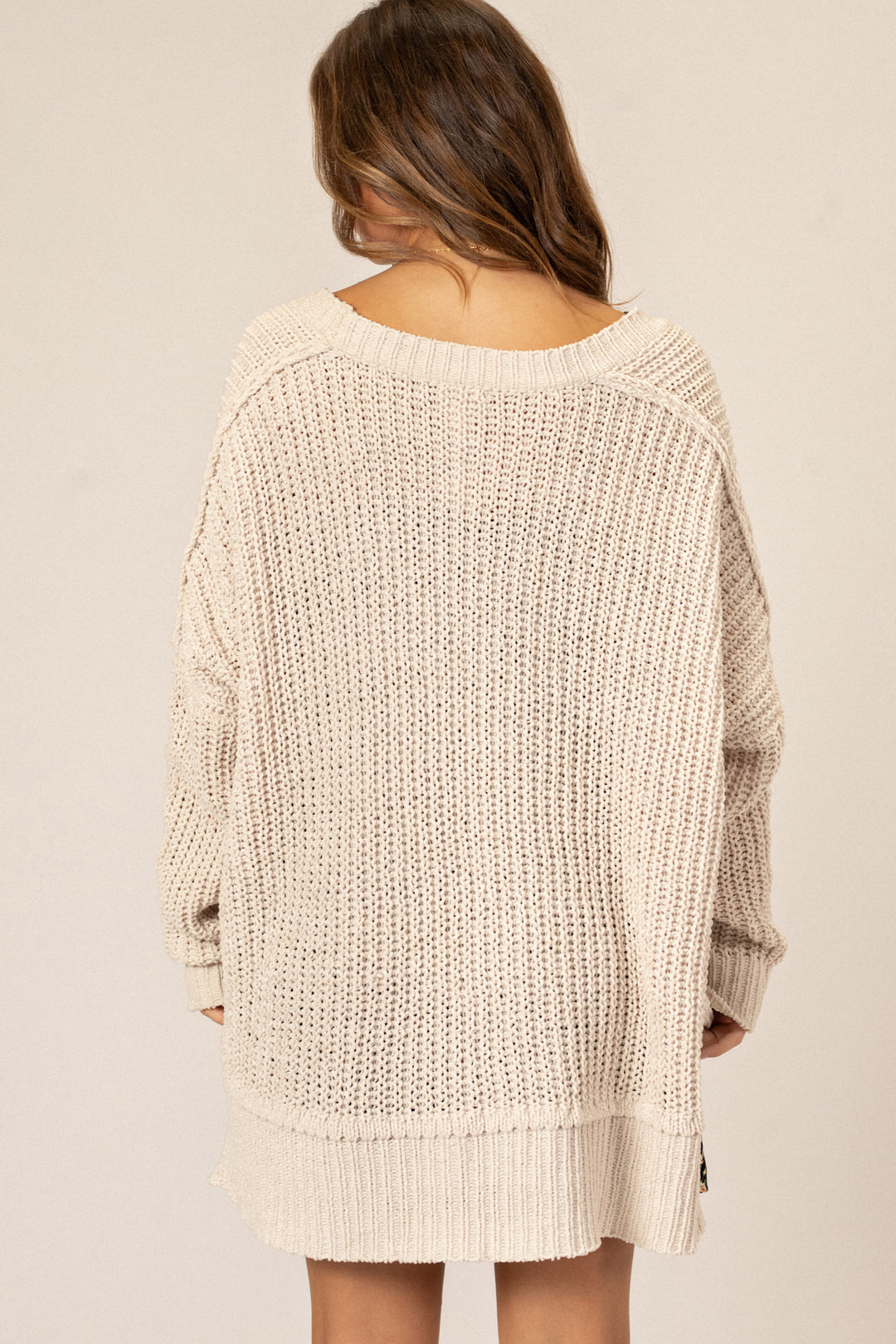 Cozy cream-colored knit cardigan with a relaxed, open front design and long sleeves.