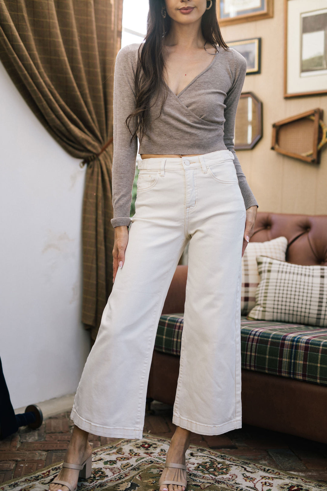 Beige wide-leg jeans with high waist and cropped length, worn with a fitted gray knit top.