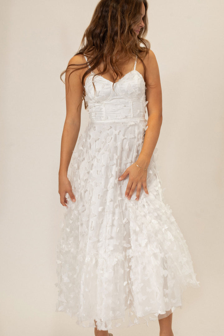 A long, flowing white dress with delicate butterfly mesh details, perfect for a special occasion.