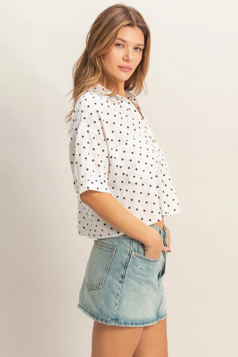 A relaxed-fit white polka dot button-up shirt with short sleeves and a classic collar.