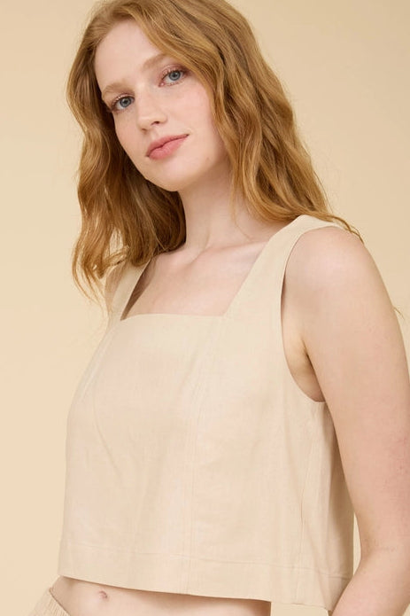 A cream-colored, square-neck tank top with a relaxed fit, worn by a model with shoulder-length wavy hair.