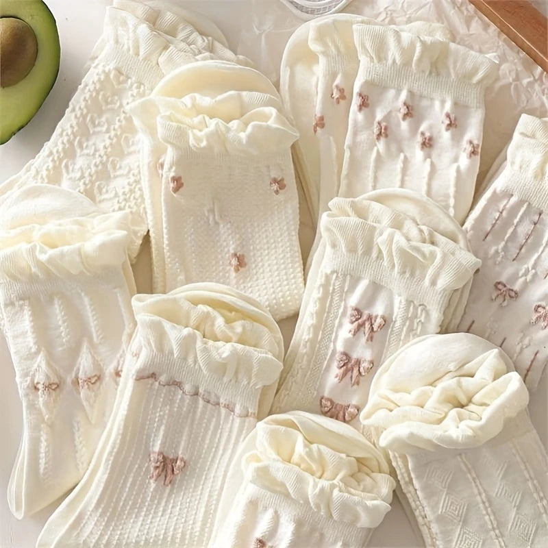 Delicate ivory ruffled socks with subtle floral embroidery, showcasing a soft, feminine design.