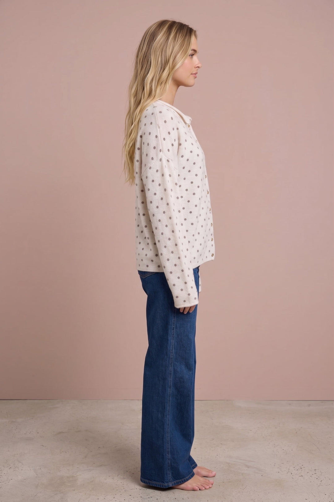 Ashley Polka Dot Knit Cardigan in cream with gray dots, side view on model wearing jeans.