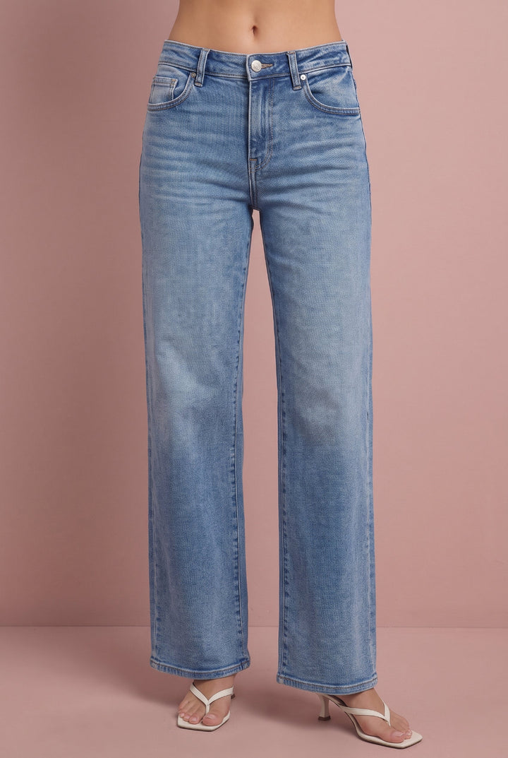 Light wash wide-leg jeans with high rise and straight leg, worn with white slide sandals