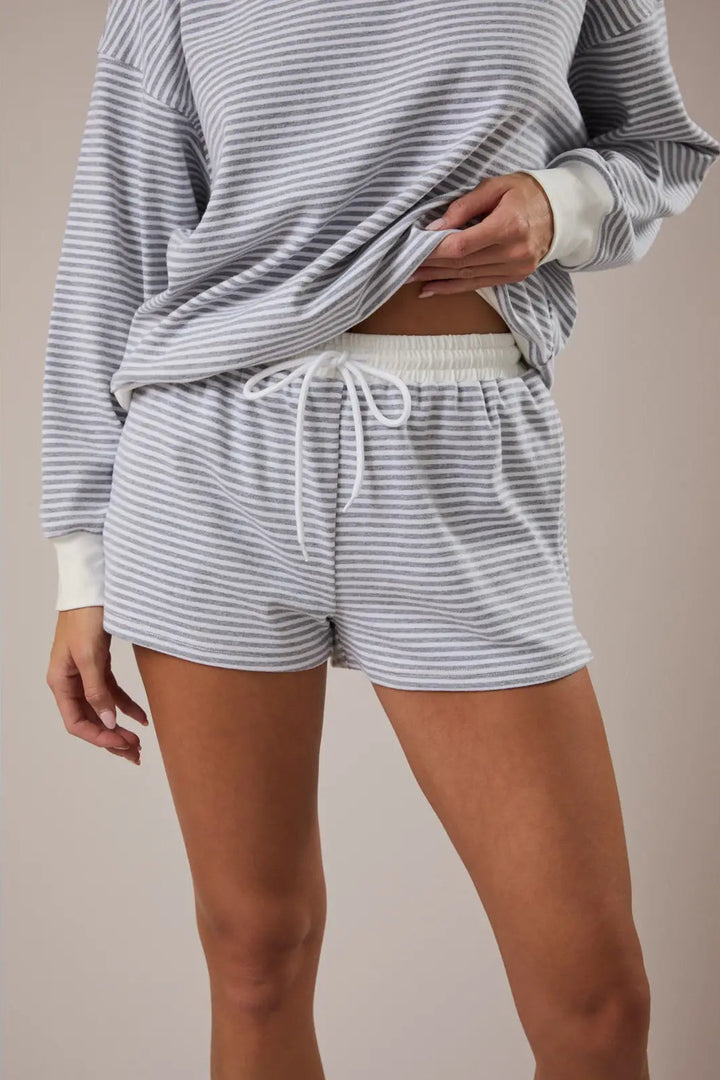 A pair of mid-rise, gray and white striped shorts with a drawstring waist and pockets.