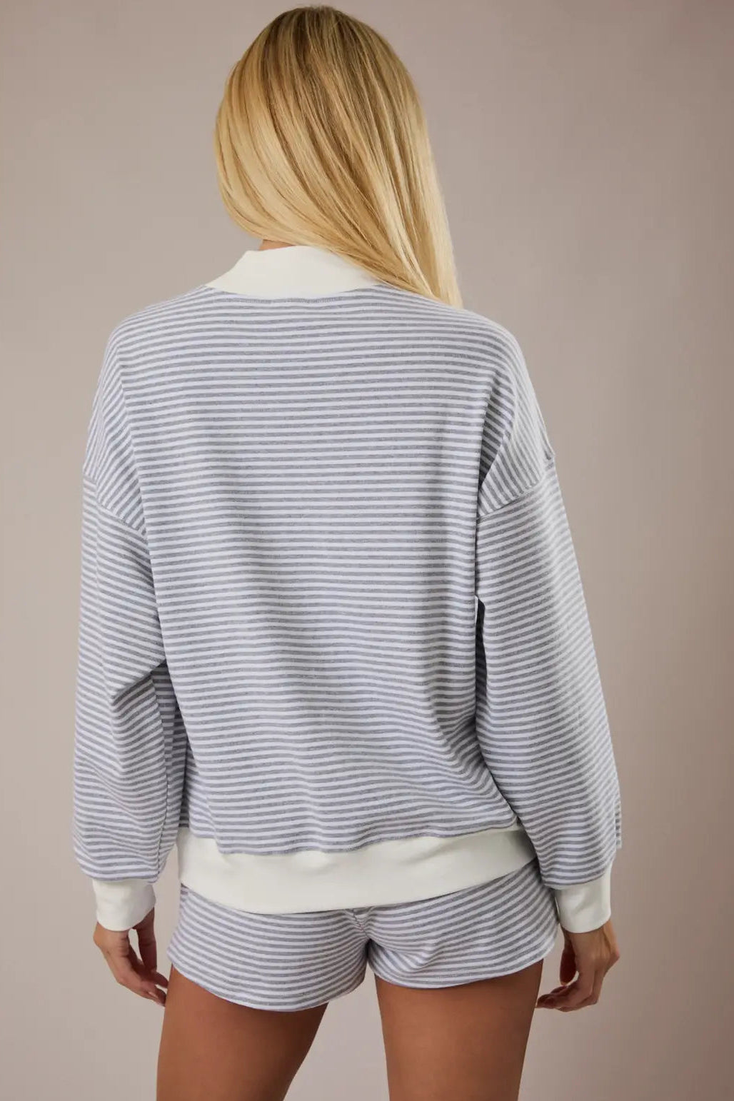 A white and gray striped mock-neck sweatshirt with a relaxed fit and long sleeves, made of a soft cotton-spandex blend.